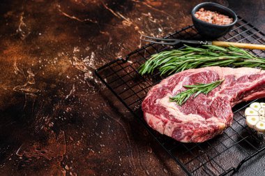 Çiğ çiğ pişmemiş kurutulmuş dana baltası ya da pirzola bifteği. Karanlık arka plan. Üst Manzara. Boşluğu kopyala.