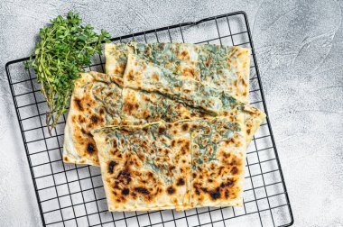 Gozleme Turkish stuffed pastrie, flatbread with greens and cheese. White background. Top view.