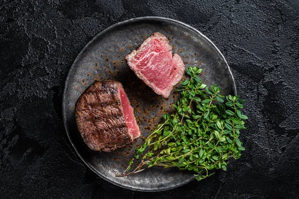 Prime Fillet Mignon Steaks, grilled beef tenderloin meat. Black background. Top view.