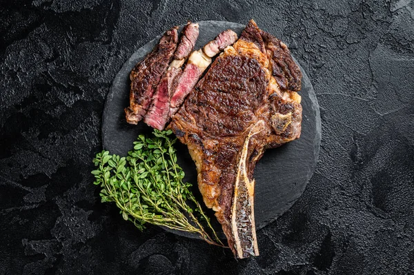 Kızarmış Tomahawk ya da biftekli kovboy. Siyah arka plan. Üst görünüm.