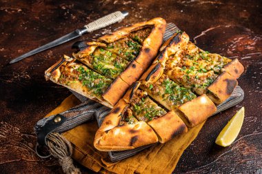 Traditional Turkish baked pide, Middle Eastern snack. Turkish pizza. Dark background. Top view.