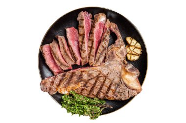 Izgara orta pişmiş biftek, T-Bone bifteği dilimlenmiş beyaz arka planda izole edilmiş bir tabak.
