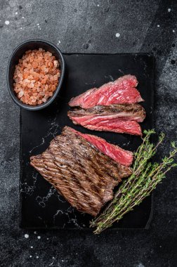 Grilled Wild Venison steak with thyme and salt, game meat. Black background. Top view.