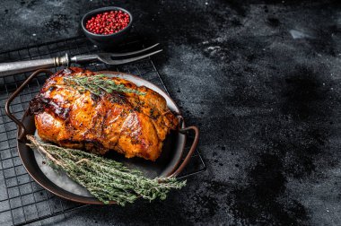 Roasted Glazed Pork meat Roll with thyme and tomato sauce. Black background. Top view. Copy space.