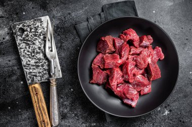 Raw Diced game meat of wild venison dear. Black background. Top view.