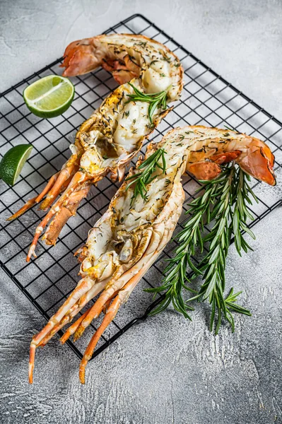 Barbecue grilled and sliced Spiny lobster or sea crayfish with herbs. White background. Top view.