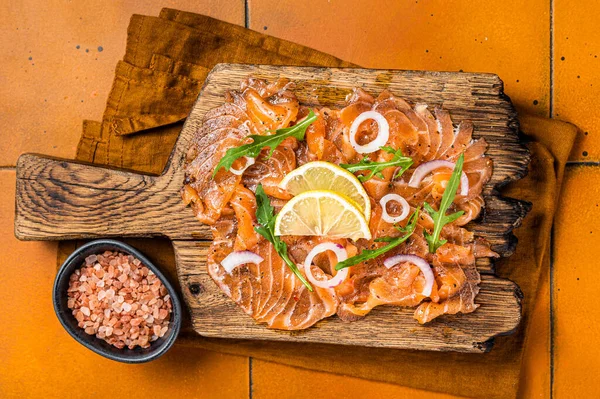 Delicious Salmon Carpaccio Slices Onion Arugula Wooden Board Orange Background — Foto de Stock