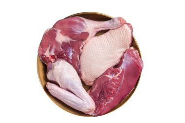 Taze ördek eti parçaları, çiğ göğüs bifteği, bacaklar, bitkilerle dolu bir tabakta kanatlar. Beyaz arkaplanda izole