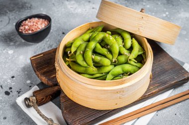 Steamed Edamame Beans with sea salt, soy beans. Gray background. Top view.
