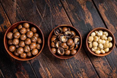 Unshelled Macadamia nuts ready to eat. Wooden background. Top view.