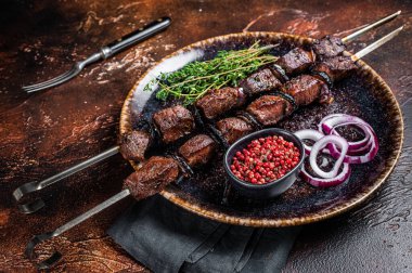 Shish kebab lamb meat BBQ with onion and spices. Dark background. Top view.