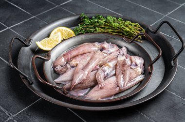 Raw squid with spices and lemon, fresh Seafood. Black background. Top view.