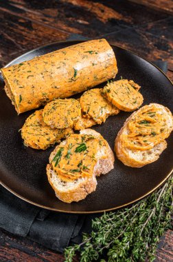 Butter with flavoring additives, sandwich butter with fresh herbs, sweet peppers, lemon, onion, garlic. Wooden background. Top view.
