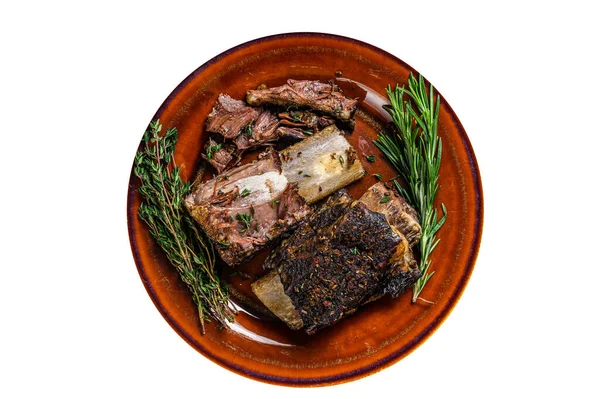 Grilled short beef ribs with thyme on a rustic plate. High quality Isolate, white background
