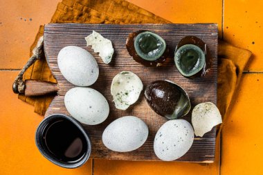 Chinese Century egg, preserved duck eggs. Orange background. Top view.