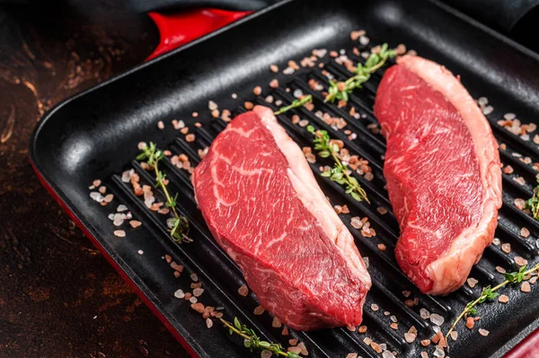 stock image Raw Cap Rump steak, marbled beef meat on a grill skillet. Dark background. Top view.