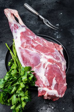 Ready for cooking raw lamb mutton leg with Thigh. Black background. Top view.