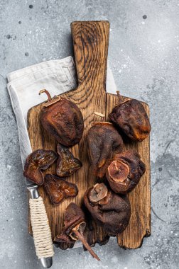 Sun Dried persimmon fruit on wooden board. Gray background. Top view.