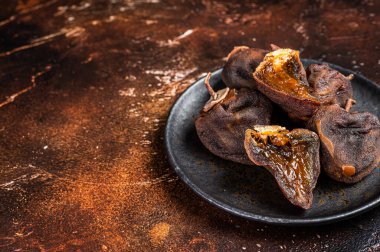 Tabakta kurutulmuş hurma meyvesi. Karanlık arka plan. Üst Manzara. Boşluğu kopyala.