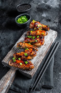 Tatlı ve ekşi soslu tavuk bufalo kanadı ve siyah susam. Siyah arka plan. Üst görünüm.