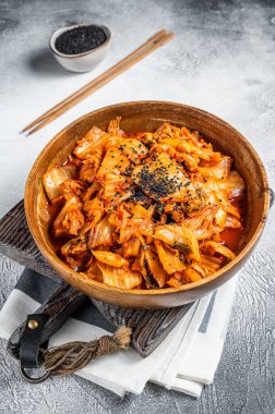 Kimchi cabbage in a wooden plate with chopsticks for eating , Korean cuisine. White background. Top view.