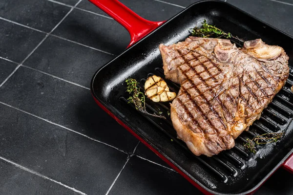 Izgara T-Bone, ızgarada biftek bifteği. Siyah arka plan. Üst Manzara. Boşluğu kopyala.