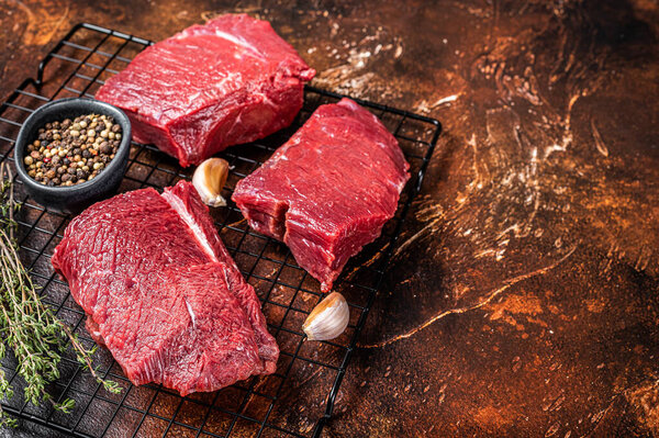 Raw Wild Game Meat of Venison dear ready for cooking. Dark background. Top view. Copy space.