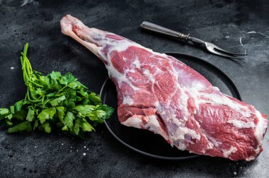 Ready for cooking raw lamb mutton leg with Thigh. Black background. Top view.