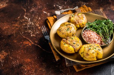 Biberiye ve kekik ile pişirilmiş ezilmiş, ezilmiş patatesler. Karanlık arka plan. Üst Manzara. Boşluğu kopyala.