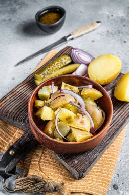 Cooking Traditional German potato salad - Kartoffelsalat. Gray background. Top view.