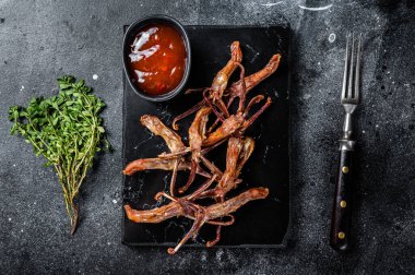 Chinese food dip fried duck tongue Black background. Top view.