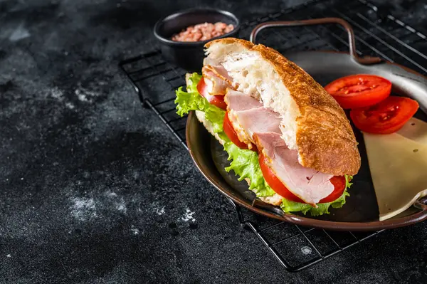 Deli meat sandwich with turkey ham, cheese, tomato and Lettuce. Black background. Top view. Copy space.