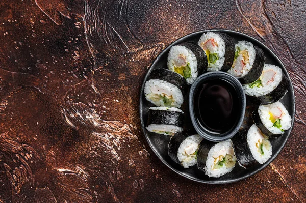 Korean rice roll Kimbap or gimbap made from steamed white rice. Dark background. Top view. Copy space.