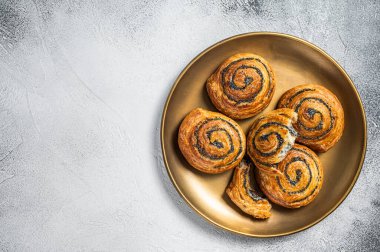 Poppy seed rolls and cardamom buns, Traditional Nordic baked sweet breads on wooden board. White background. Top view. Copy space.