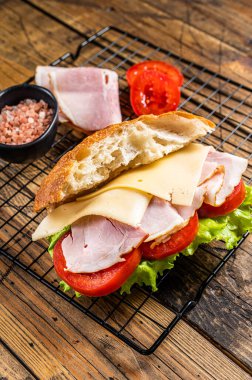 Sub sandwich with ham, cheese, tomato and Lettuce. Wooden background. Top view.