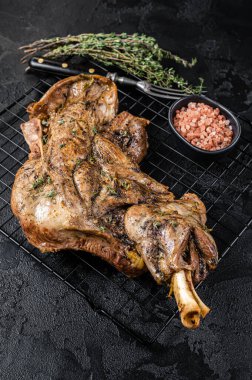 Barbecue Roasted lamb mutton shoulder meat with herbs and spices. Black background. Top view.