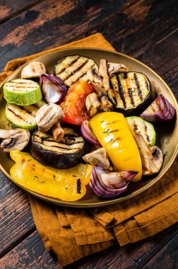Various grilled Vegetables, bell pepper, zucchini, eggplant, onion and tomato. Wooden background. Top view.