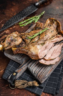 Slow Cooked grilled lamb mutton shoulder meat with herbs and spices on wooden board. Dark background. Top view.