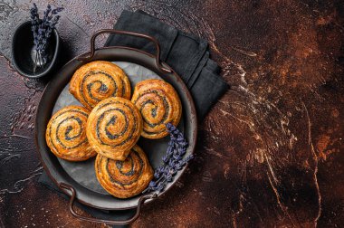 Haşhaş tohumlu ve lavantalı tatlı çörek. Karanlık arka plan. Üst Manzara. Boşluğu kopyala.