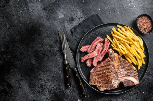 ポーターハウスは牛肉の肉ステーキを焼き フレンチフライドポーターハウスで皿に骨を調理しました ブラックバック トップビュー コピースペース — ストック写真