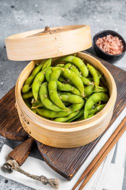 Steamed Edamame Beans with sea salt, soy beans. Gray background. Top view.