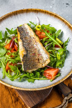 Sebze salatalı kızarmış levrek fileto, Dicentrarchus balığı. Gri arka plan. Üst görünüm.