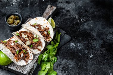 Mısır ekmeğinde domuz carnitas taco soğan ve limonlu tortilla. Siyah arka plan. Üst Manzara. Boşluğu kopyala.