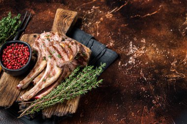 Izgara Yeni Zelanda Kuzu Pirzolası, tahta üzerinde koyun pirzolası. Karanlık arka plan. Üst Manzara. Boşluğu kopyala.