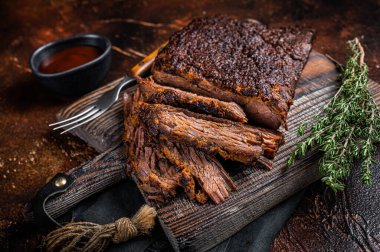 Traditional smoked barbecue wagyu beef brisket on wooden board. Dark background. Top view.