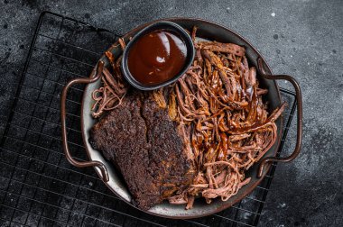Slow Cooked Pulled Beef, Traditional meat rubbed with spices and smoked in a Texas smoker. Black background. Top view.