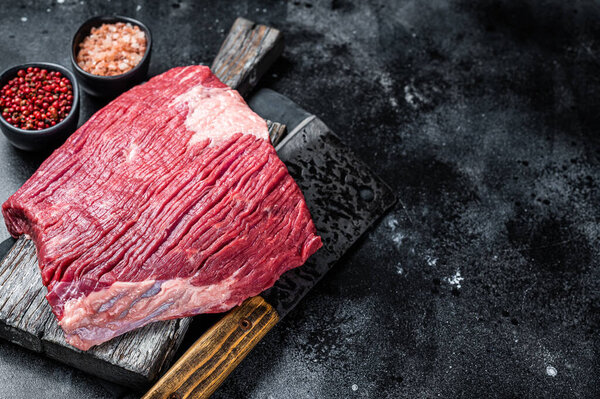 Uncooked Raw beef brisket meat on butcher board. Black background. Top view. Copy space.