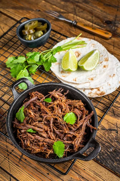 Cooking of mexican pork carnitas taco. Wooden background. Top view.