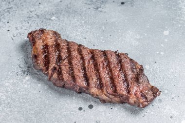 BBQ Grilled denver beef meat steak on a table. Gray background. Top view.