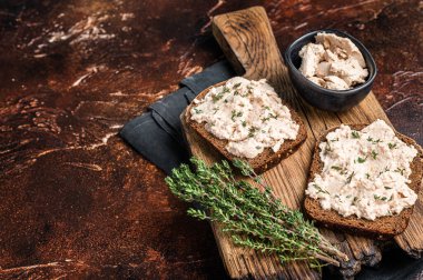 Tahtada morina ciğeri sandviçi açık. Karanlık arka plan. Üst Manzara. Boşluğu kopyala.